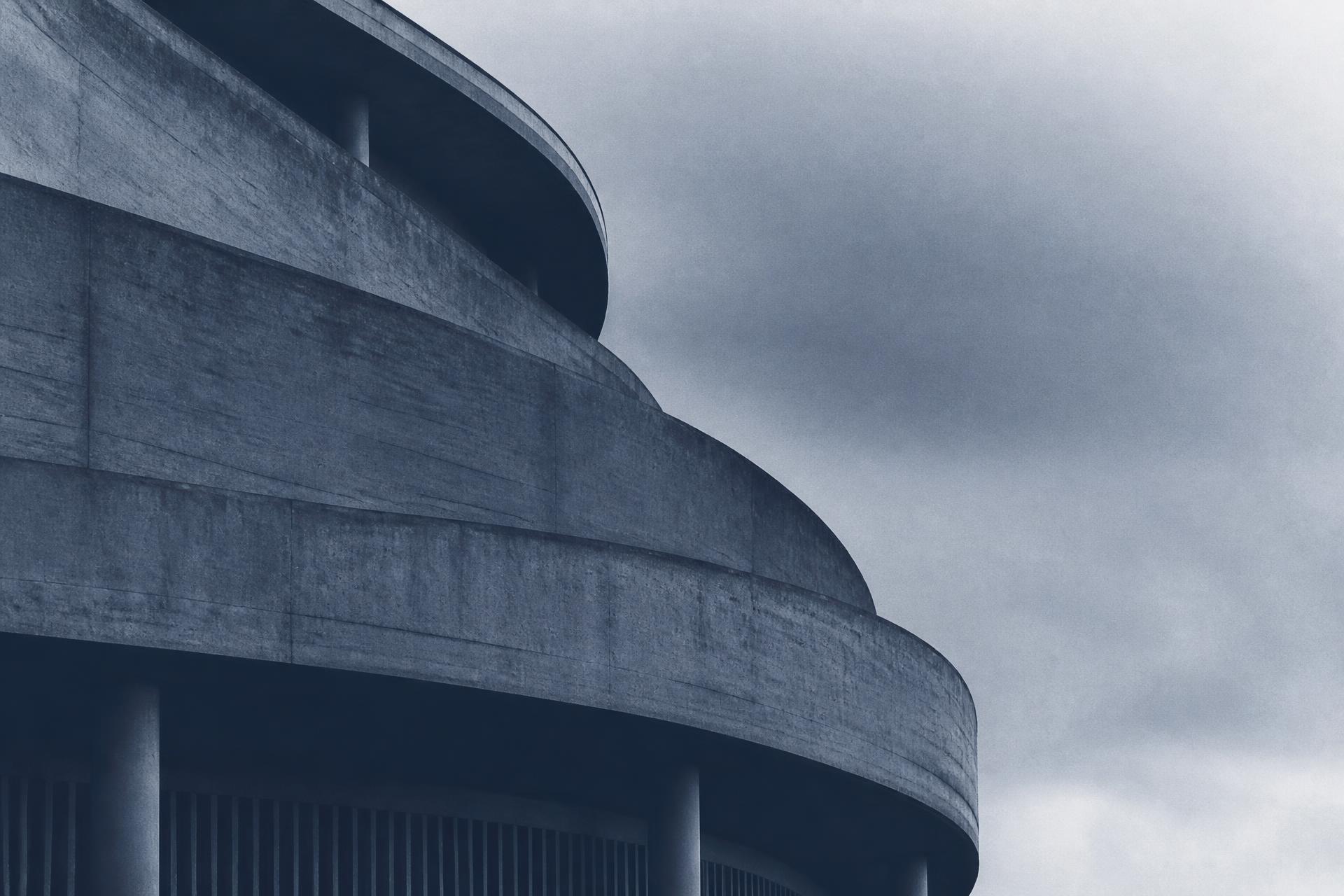 Curved concrete facade of modern European architecture in muted blue-grey